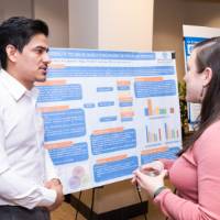 Gautam (left) presenting to a guest at the 2023 Graduate Showcase.